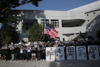 Protesters gather near the words "Missing Classmate Chow" outside the residence of the President of the University of Science and Technology in Hong Kong on Friday, Nov. 8, 2019. Chow Tsz-Lok, a student from the University who fell off a parking garage after police fired tear gas during clashes with anti-government protesters died Friday, in a rare fatality after five months of unrest that intensified anger in the semi-autonomous Chinese territory. (AP Photo/Kin Cheung)