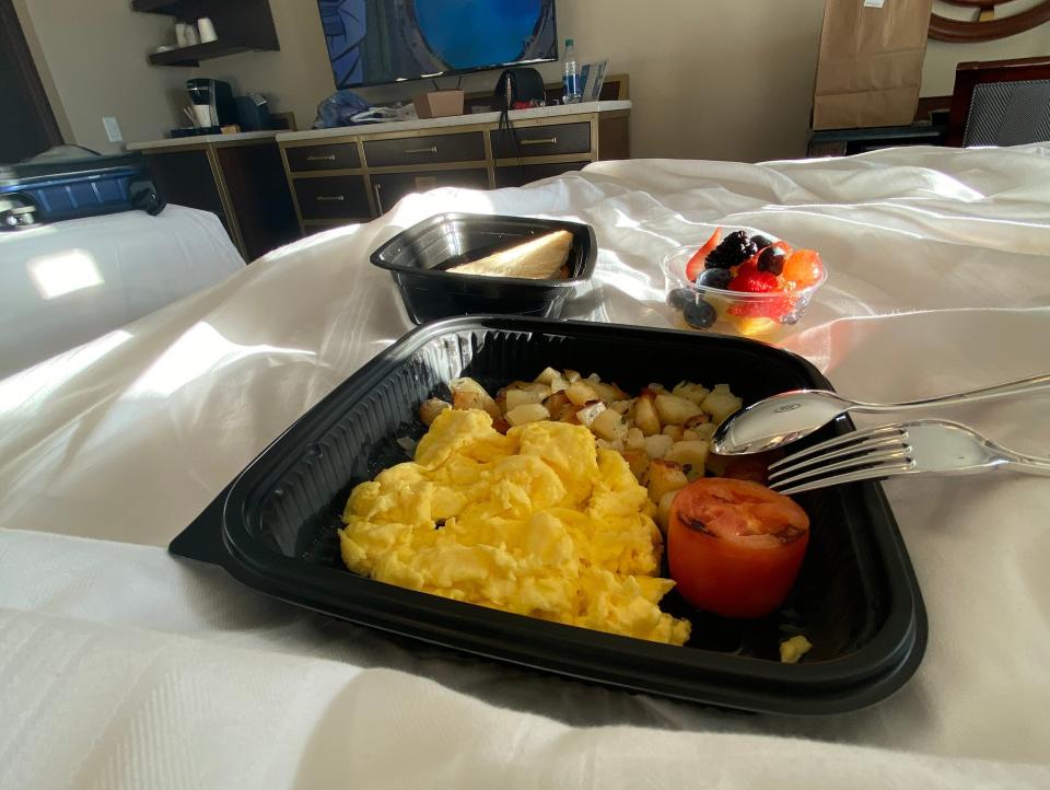 takeout container of food on a hotel bed at disney world