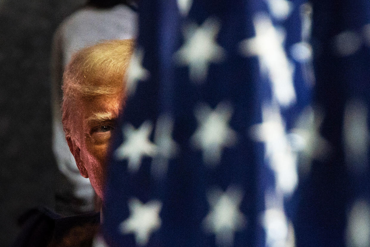 Donald Trump behind flag MATTHEW HATCHER/AFP via Getty Images