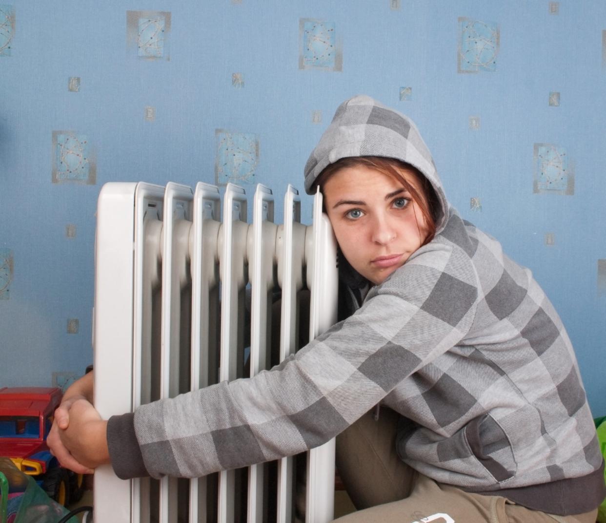 Eine junge Frau hat sich einen strombetriebenen Heizlüfter gekauft, weil heizen mit Gas so teuer geworden ist in Deutschland. - Copyright: Khvost/Shutterstock