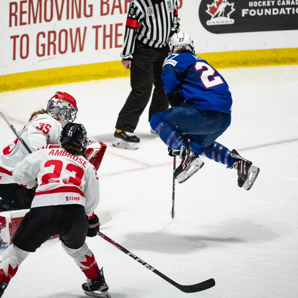 USA's Taylor Heise leaps into the air to avoid being hit from a teammate's shot against Canada Monday at the Adirondack Bank Center.