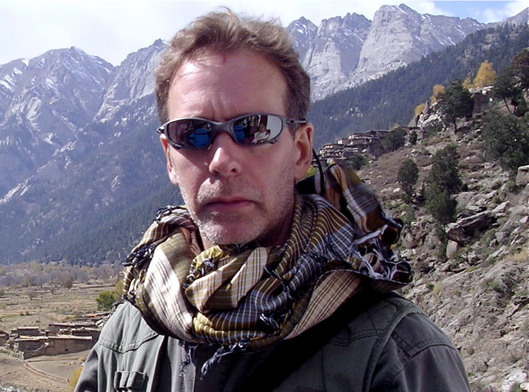 Kenny Leahman, wearing sunglasses, with mountains in the background.