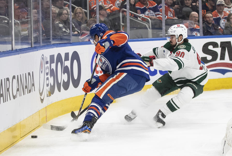 Minnesota Wild's Marcus Johansson (90) and Edmonton Oilers' Cody Ceci (5) vie for the puck during the first period of an NHL hockey game Friday, Feb. 23, 2024, in Edmonton, Alberta. (Jason Franson/The Canadian Press via AP)