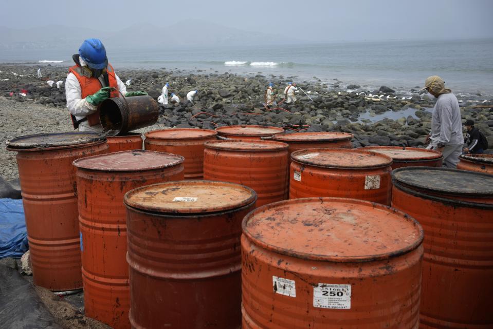 Workers continue in a clean-up campaign after an oil spill, on Pocitos Beach in Ancon, Peru, Tuesday, Feb. 15, 2022. One month later, workers continue the clean-up beaches after contamination by a Repsol oil spill. (AP Photo/Martin Mejia)