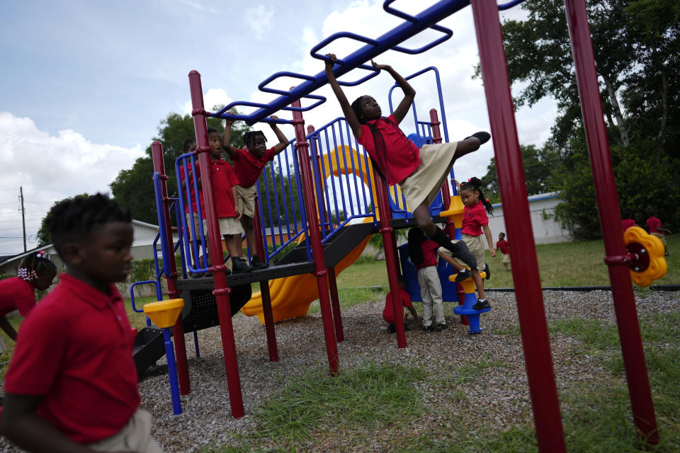 Students from Thomas Leadership Academy play on the school's playground in Eatonville, Fla., Wednesday, Aug. 23, 2023. (AP Photo/Rebecca Blackwell)