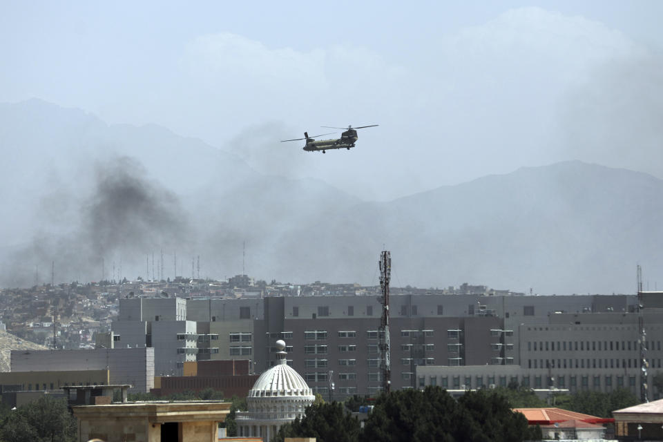 A U.S. Chinook helicopter flies over the city of Kabul, Afghanistan, Sunday, Aug. 15, 2021. Taliban fighters entered the outskirts of the Afghan capital on Sunday, further tightening their grip on the country as panicked workers fled government offices and helicopters landed at the U.S. Embassy. (AP Photo/Rahmat Gul)