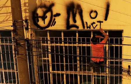 A "pichador", a graffiti artist who tags buildings, who lost his legs after suffering an accident while hopping trains, paints his personal signature, called "pichacao", on a wall of a house, in Sao Paulo, Brazil, April 19, 2017. REUTERS/Nacho Doce