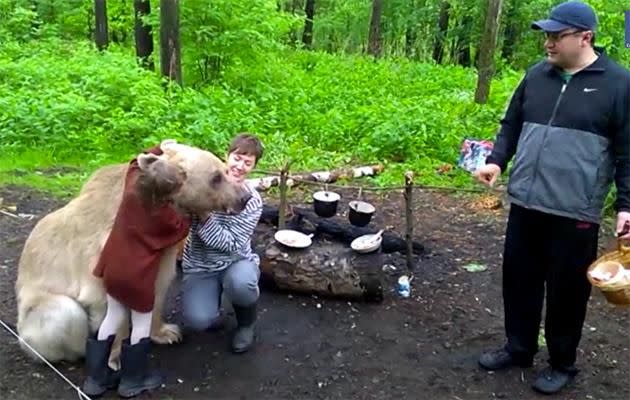 The child cuddles the bear as if it is an actual teddy bear.