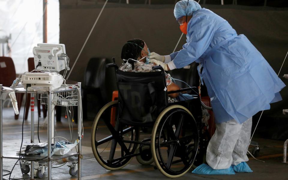 A healthcare worker tends to a coronavirus patient at Steve Biko Academic Hospital in Pretoria, in January - Reuters