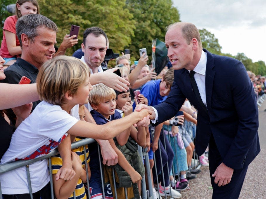 Prince William shakes hands with members of the public gathered to pay their respects to Queen Elizabeth