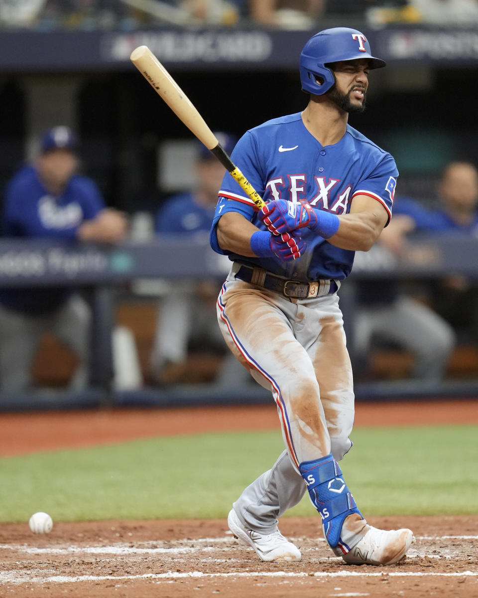 Texas Rangers' Leody Taveras grimaces as he fouls a pitch that hit his foot during the fifth inning of Game 1 in an AL wild-card baseball playoff series game against the Tampa Bay Rays, Tuesday, Oct. 3, 2023, in St. Petersburg, Fla. (AP Photo/John Raoux)