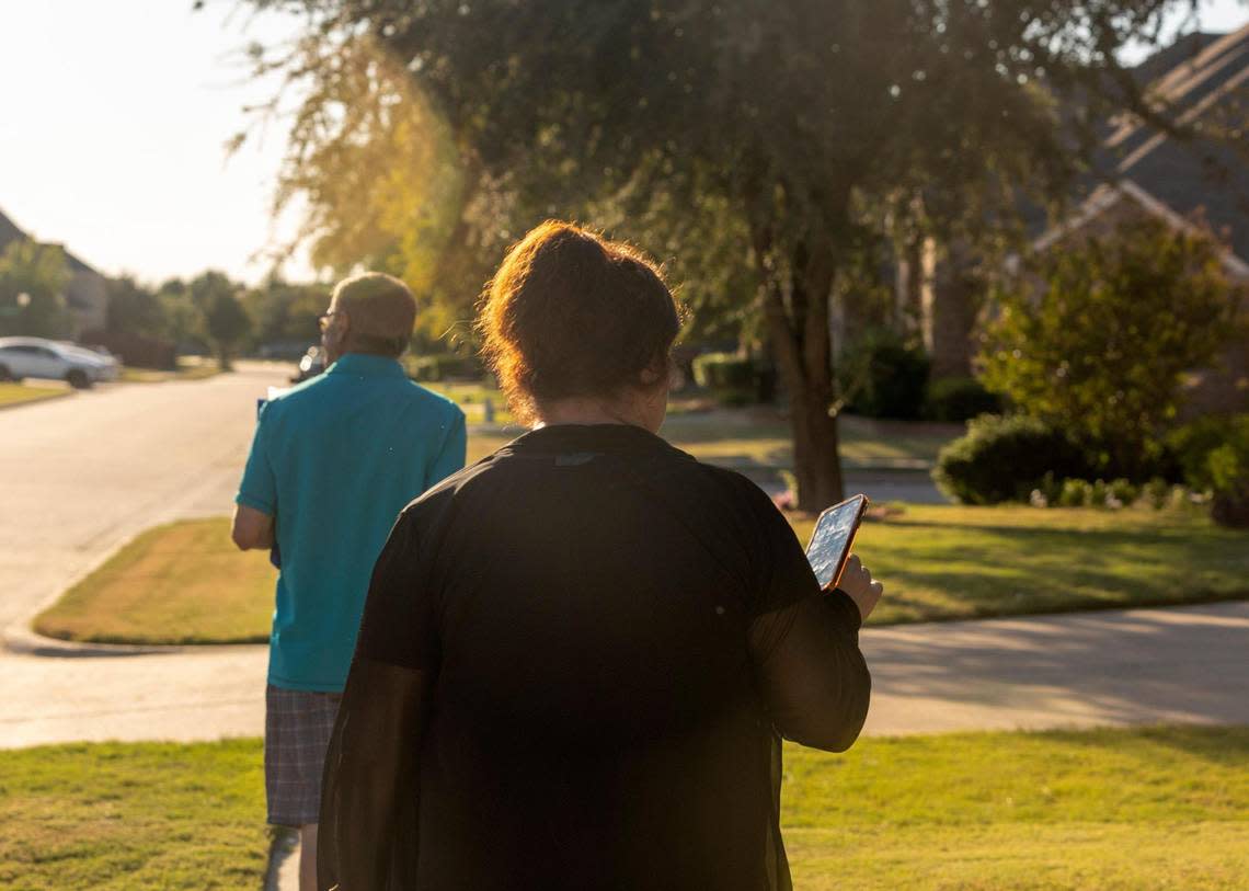 Amjad and Nadia Bhular walk between homes, canvassing their neighborhood and providing campaign flyers supporting Democrats in Grand Prairie, Texas, on Wednesday, Oct. 5, 2022. A mobile app helps her track what home to go to next and who answers their door.