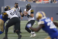 Hamilton Tiger-Cats quarterback Jeremiah Masoli (8) drops back during the first half of a Canadian Football League game against the Winnipeg Blue Bombers on Thursday, Aug. 5, 2021, in Winnipeg, Manitoba. (John Woods/The Canadian Press via AP)