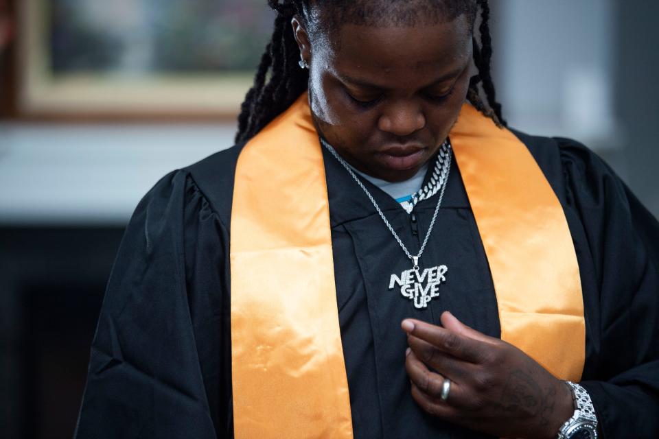 Da'maryious Dorsey looks at his necklace as a a reminder to never give up, at his friend's home in Hermitage, Tenn., Saturday, July 8, 2023. Dorsey worked toward a Dyersburg State Community College associate's degree in business management while he was in prison.