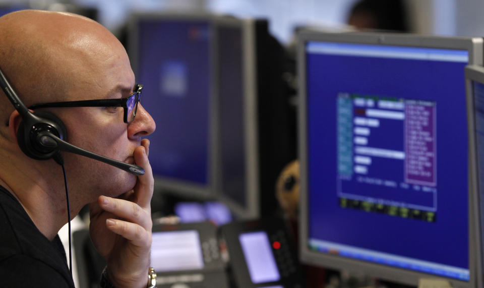 A trader monitors the screen on a trading floor in London. Stock markets were up on Thursday