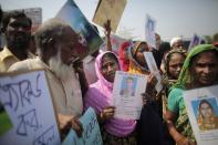 Relatives of victims killed in the collapse of Rana Plaza hold pictures on the first year anniversary of the accident, as they gather in Savar April 24, 2014. Protesters and family members of victims demand compensation on the one year anniversary of the collapse of Rana Plaza, in which more than 1,100 factory workers were killed and 2,500 others were injured.