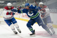 Vancouver Canucks center Jay Beagle (83) is defended by Montreal Canadiens' Brett Kulak (77) and Alexander Romanov (27) during second period NHL action in Vancouver, Wednesday, January 20, 2021. THE CANADIAN PRESS/Jonathan Hayward/The Canadian Press via AP)