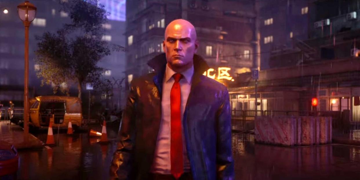 hitman 3, agent 47 walks through a rainy neon city