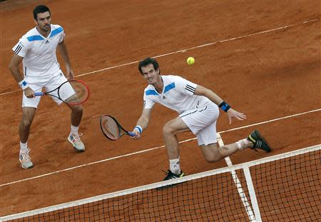 Britain's Andy Murray (R) returns a ball as his teammate Colin Fleming looks on during their Davis Cup quarter-final doubles tennis match against Italy's Fabio Fognini and Simone Bolelli in Naples April 5, 2014. REUTERS/Alessandro Bianchi