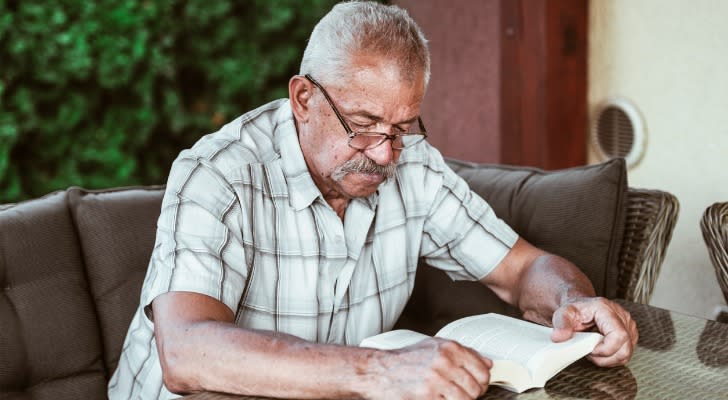 A man reading a book because he ran out of money during retirement