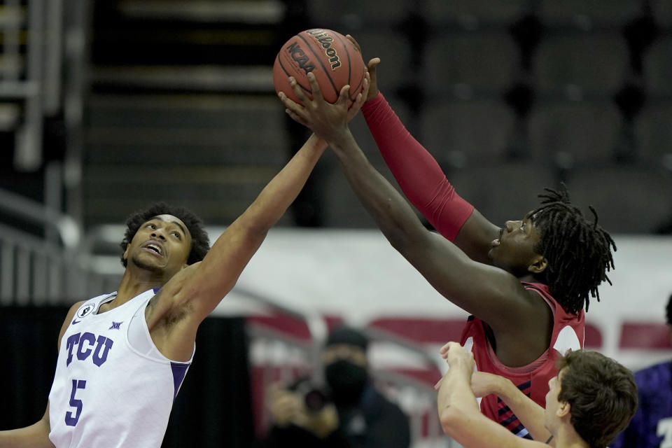 Liberty's Micaiah Abii, right, and TCU's Chuck O'Bannon Jr. (5) battle for a rebound during the first half of an NCAA college basketball game Sunday, Nov. 29, 2020, at the T-Mobile Center in Kansas City, Mo. (AP Photo/Charlie Riedel)