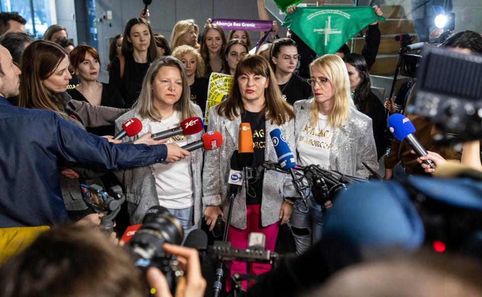 Activist, Justyna Wydrzyńska,center, speaks to reporters in Warsaw, Poland, on Tuesday March 14, 2023. A court on Tuesday convicted Wydrzyńska for helping a victim of domestic violence access abortion pills in Poland, and sentenced her to eight months of community service.
