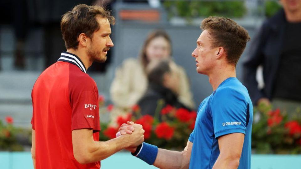 Daniil Medvedev shakes hands with Jiri Lehecka of Czech Republic after having to retire 