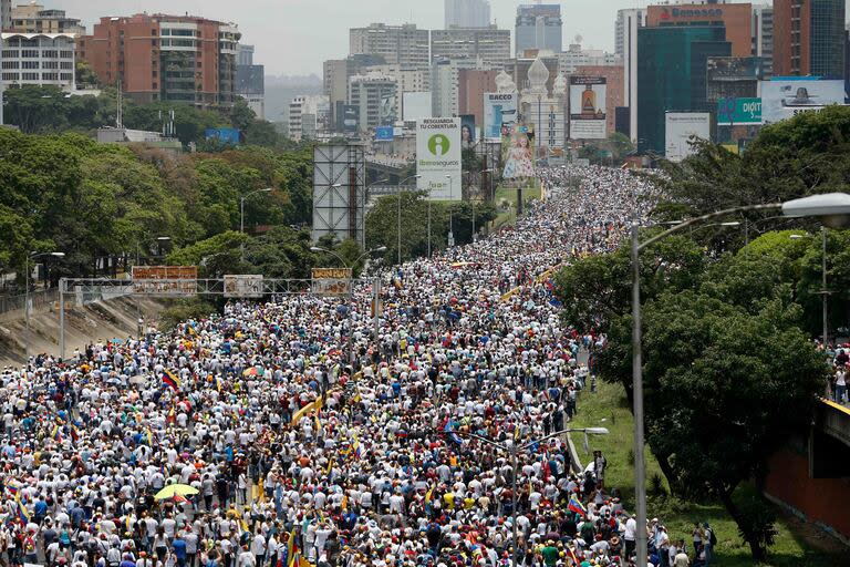 Manifestantes contrarios al gobierno marchan junto a una autopista en Caracas, Venezuela, el 19 de abril de 2017 (AP Foto/Ariana Cubillos, Archivo)