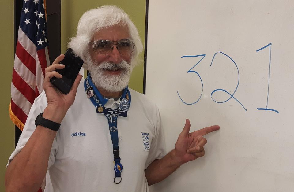 Ozzie Osband stands at a whiteboard displaying Brevard County's 321 area code during a Titusville Area Chamber of Commerce luncheon.
