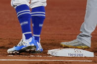 Israel first baseman Danny Valencia, left holds United States' Eric Filia, right, on first base during a baseball game at the 2020 Summer Olympics, Friday, July 30, 2021, in Yokohama, Japan. Valencia's shoes show a pattern of the Star of David. (AP Photo/Sue Ogrocki)