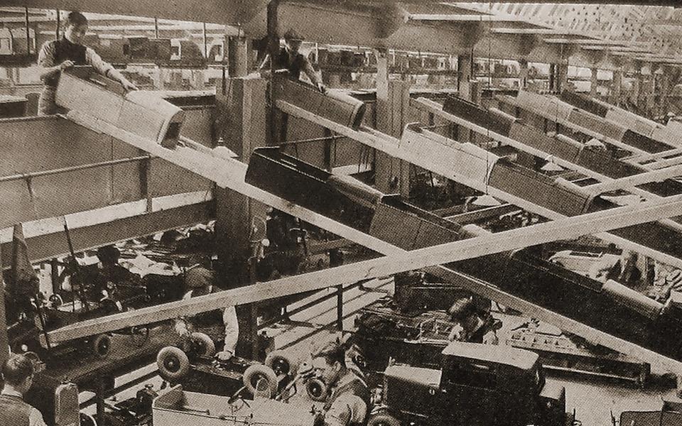 Racing cars being pushed down chutes in the factory