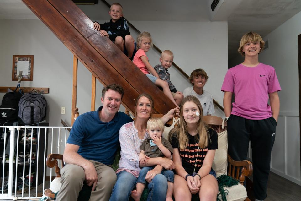The Budge family poses on their stairwell for a photo Monday. Bottom row, from left, are parents Tim and Sunny Budge; Tate, 1; and Norah, 12, and top row, from left, are Ezra, 8; Tessa, 6; Charlie, 4; Wesley, 15; and David, 14.