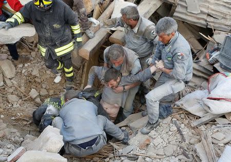 A man is rescued alive from the ruins following an earthquake in Amatrice, central Italy, August 24, 2016. REUTERS/Remo Casilli