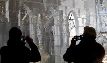 Visitors take pictures of a gothic-style ice dome, made from 90 tonnes of ice, at the mountain resort of Hrebienok near the town of Stary Smokovec, Slovakia November 28, 2016. Picture taken November 28, 2016. REUTERS/David W Cerny