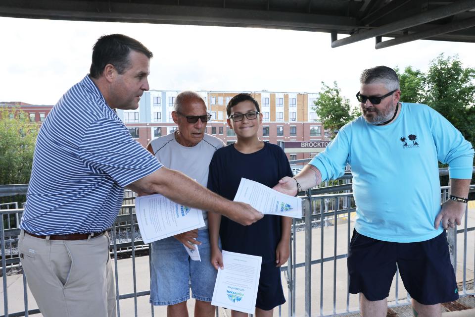 From left, Brockton Mayor Robert Sullivan handed out free passes to Bob Olitsky, Dominic Gonzalez, 12, and Matt Stanton to ride the Cape Cod Flyer on Friday, Aug. 12, 2022.  The Flyer runs every weekend of the summer between Memorial Day weekend and Labor Day weekend. This summer, ridership from the Brockton stop to the Cape has increased.