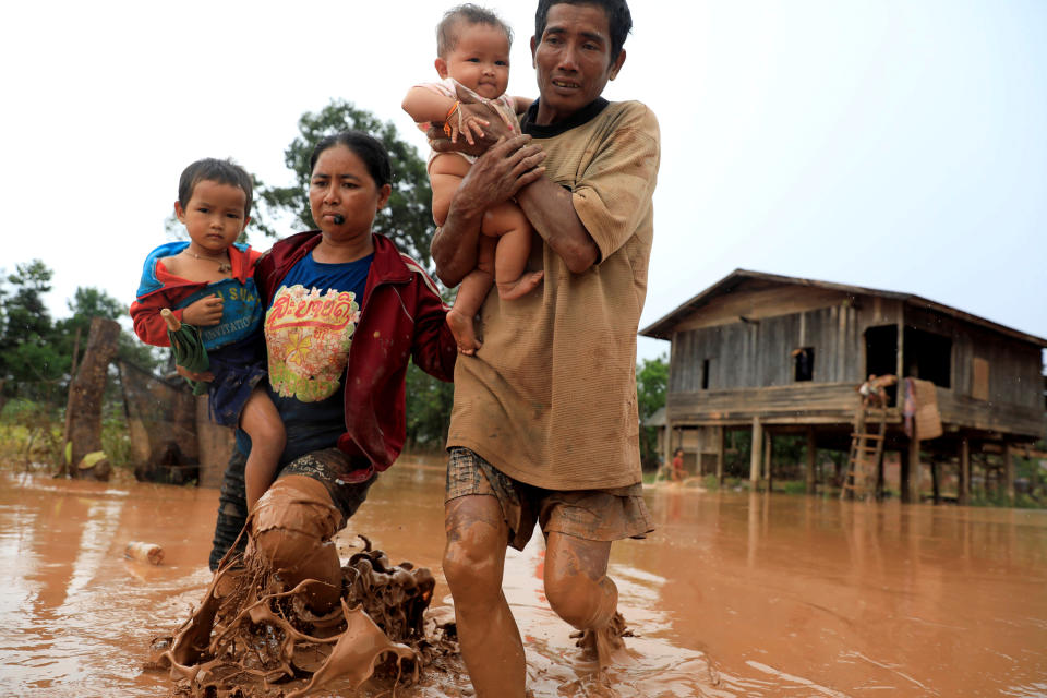 <p>Parents carry their children as they leave their home during the flood after the Xepian-Xe Nam Noy hydropower dam collapsed in Attapeu province, Laos, July 26, 2018. (Photo: Soe Zeya Tun/Reuters) </p>