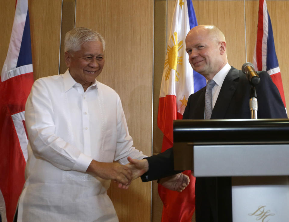 British Foreign Secretary William Hague, right, shakes hands with his Philippine counterpart Albert del Rosario following their joint news conference Thursday, Jan. 30, 2014 in Manila, Philippines. Hague said the United Kingdom will take in some refugees from the Syrian conflict to "give them some respite and some care after some of the things that they have been through." (AP Photo/Bullit Marquez)