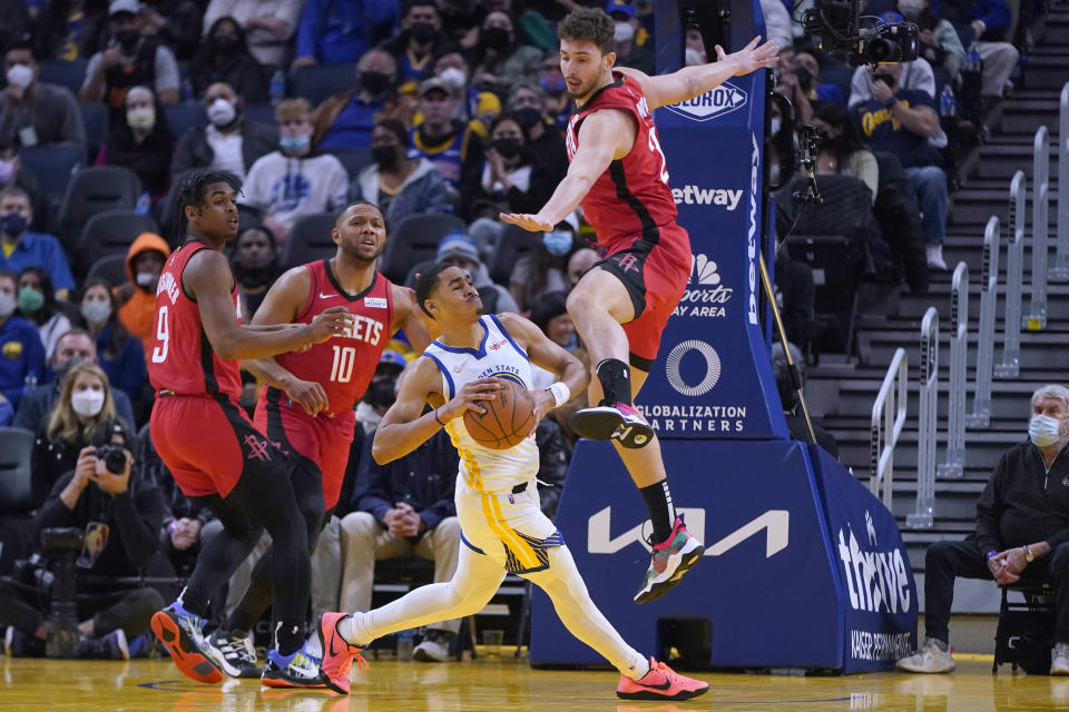 Golden State Warriors guard Jordan Poole, bottom, looks to pass while being defended by Houston Rockets guard Josh Christopher (9), guard Eric Gordon (10) and center Alperen Sengun during the first half of an NBA basketball game in San Francisco, Friday, Jan. 21, 2022. (AP Photo/Jeff Chiu)