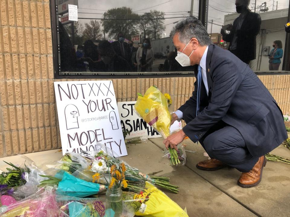 California Rep. Mark Takano lays flowers in front of Aromatherapy Spa in Atlanta, another shooting site, Sunday, March 28, 2021. (AP Photo/Sudhin Thanawala)