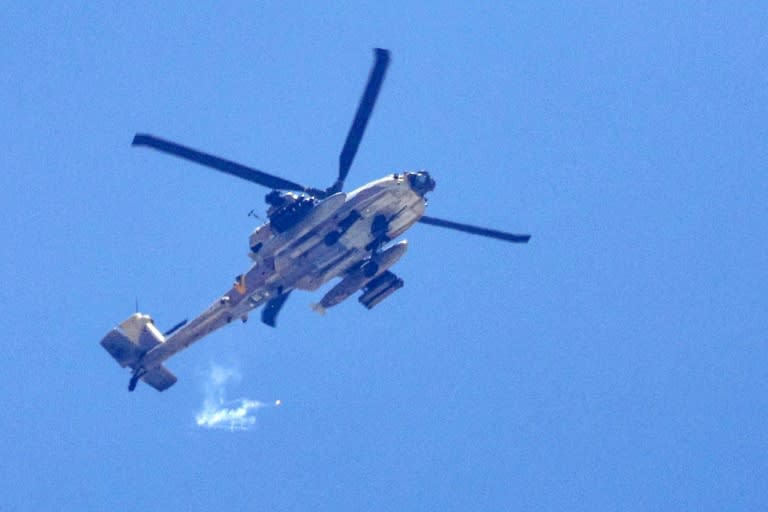 An Israeli attack helicopter fires flares while flying near the border with the Gaza Strip (JACK GUEZ)