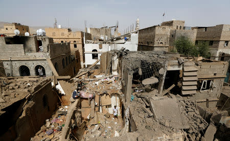 FILE PHOTO: People check damage at the site of an air strike in Amran, Yemen June 25, 2018. REUTERS/Khaled Abdullah/File Photo