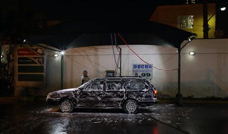 A worker washes a car at a petrol station in Sao Paulo April 8, 2014. REUTERS/Nacho Doce