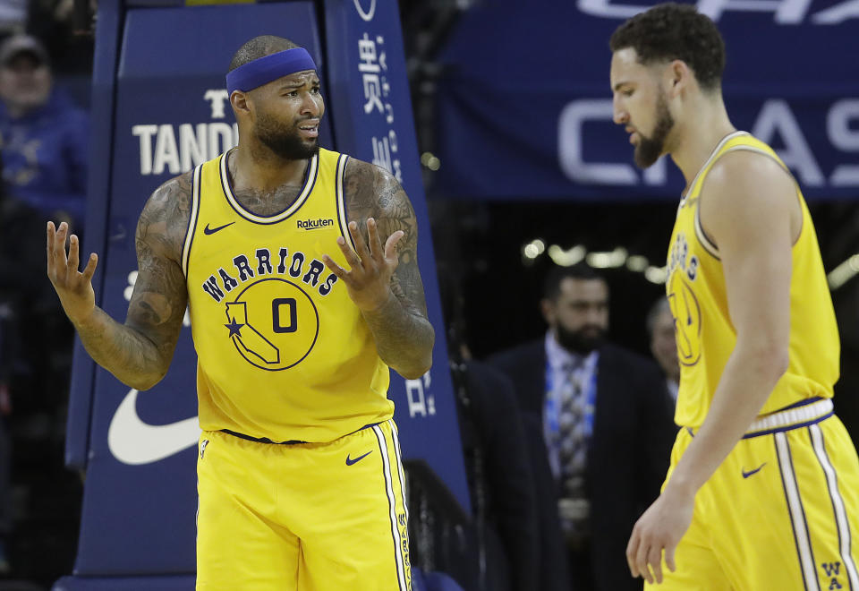 Golden State Warriors center DeMarcus Cousins, left, reacts to an official's call next to Klay Thompson during the second half of an NBA basketball game against the Phoenix Suns in Oakland, Calif., Sunday, March 10, 2019. (AP Photo/Jeff Chiu)