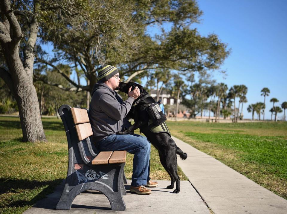 Jorel Wester takes a break with his service dog, Betsy, in a local park. Once considering suicide, the U.S. Coast Guard veteran was inspired to contact K9s for Warriors after seeing an ad for the group on a soda cup.