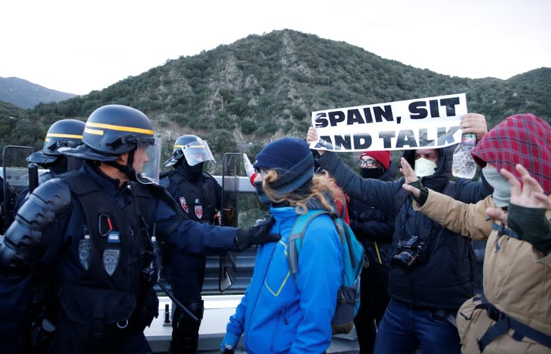 Members of Catalan protest group Democratic Tsunami clash with French police officers at the AP-7 highway