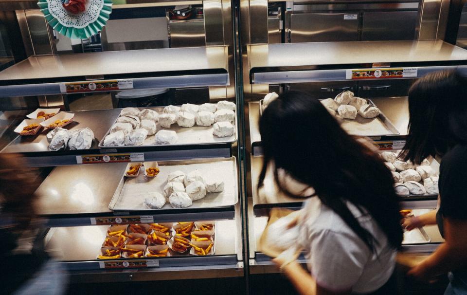 Students choose wrapped lunch items from a case.