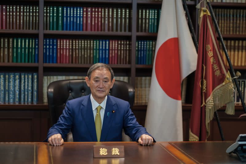 Yoshihide Suga poses for a picture following a press conference in Tokyo