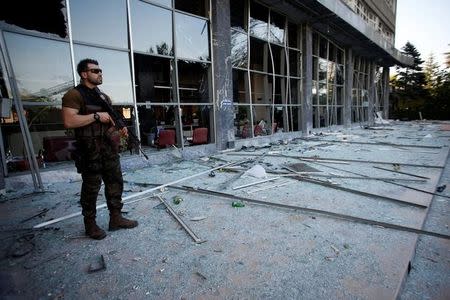 An armed special forces policeman stands in front of the police headquarters damaged by fighting during a coup attempt in Ankara,Turkey, July 19, 2016. REUTERS/Baz Ratner/Files