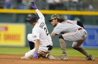 Colorado Rockies' Yonathan Daza, left, slides safely into second base with a double as Cincinnati Reds second baseman Jonathan India applies the tag in the fourth inning of a baseball game Friday, May 14, 2021, in Denver. (AP Photo/David Zalubowski)