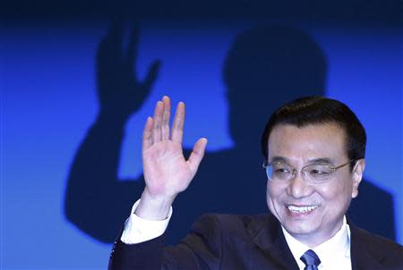 China's Premier Li Keqiang waves during a news conference, after the closing ceremony of the Chinese National People's Congress (NPC) at the Great Hall of the People, in Beijing March 13, 2014. REUTERS/Barry Huang
